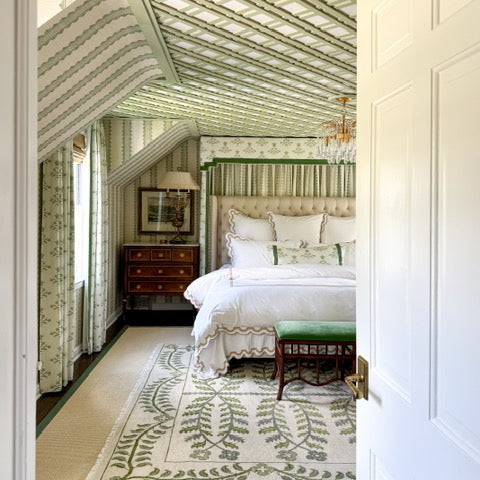 Decorative bedroom with patterned ceiling and rug, featuring a bed and dresser.