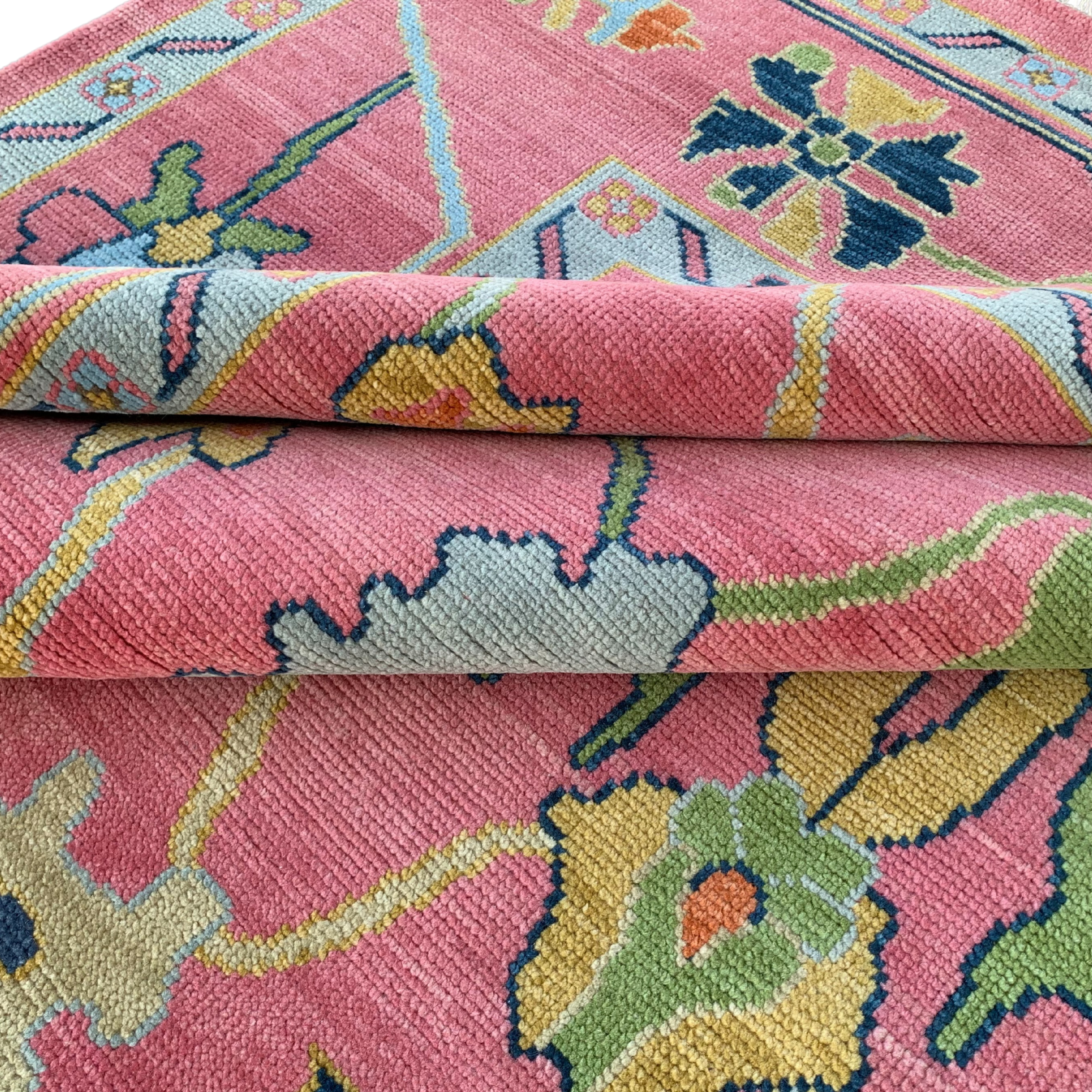 Close-up of a colorful floral-patterned rug with pink background