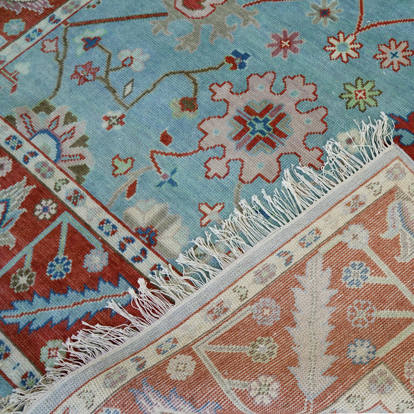 Close-up of patterned rugs with intricate designs and fringes.
