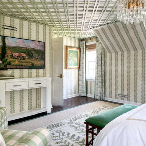 Decorative bedroom with striped wallpaper, a chandelier, and a painting.