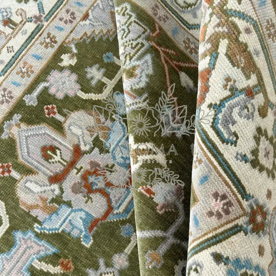 Close-up view of a moss green rug with detailed floral patterns.