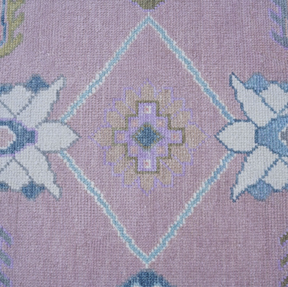 Close-up of a patterned fabric with geometric shapes on a purple background