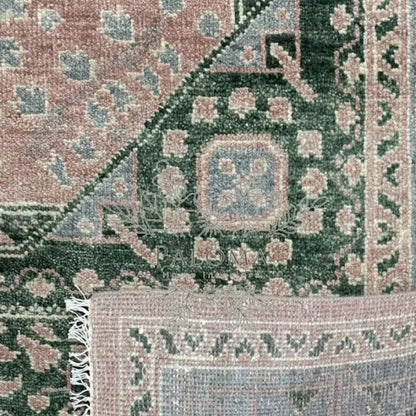 Close-up view of a green and pink floral patterned rug.