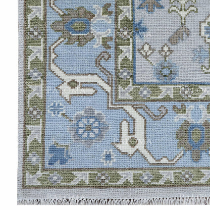 Blue and green floral wool area rug shown from an angled view